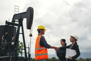 engineering-team-stands-beside-working-oil-pumps-with-sky-scaled